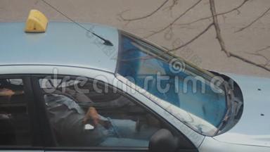 出租车司机在停着的车里休息，同时检查他手中的手机。 大多数订单是从调度员那里收到的